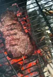NY Strip Steak over coals with thermometer