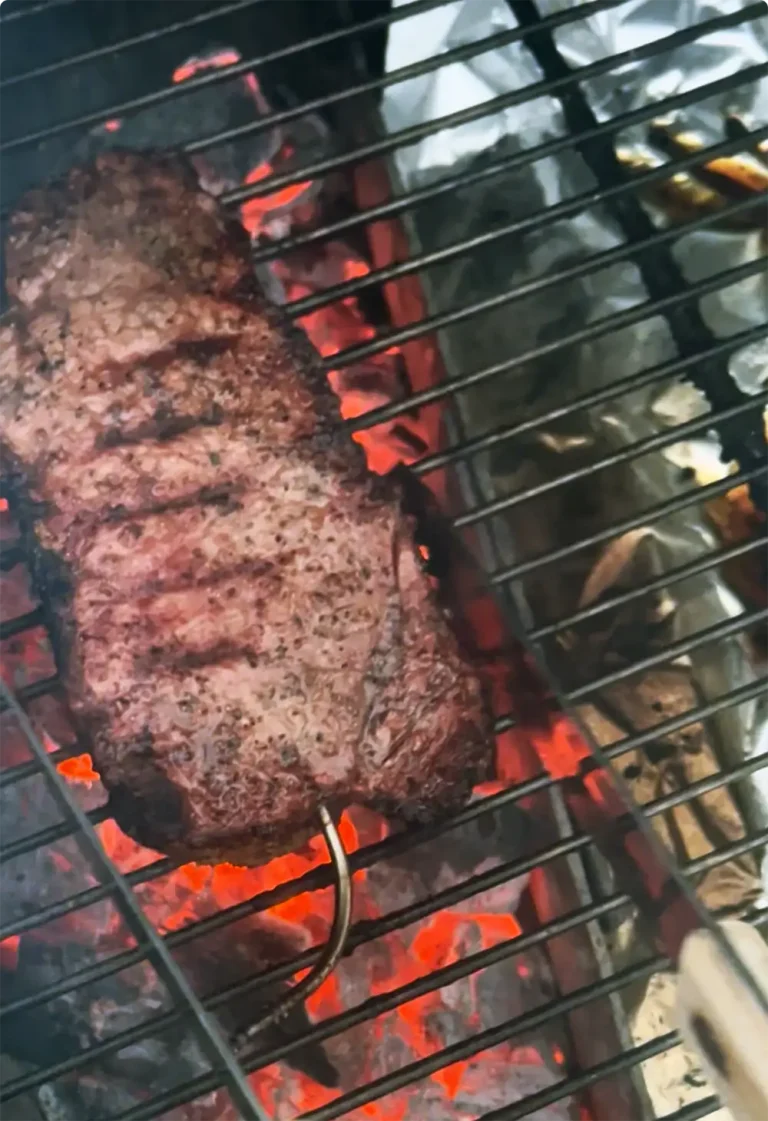 NY Strip Steak over coals with thermometer